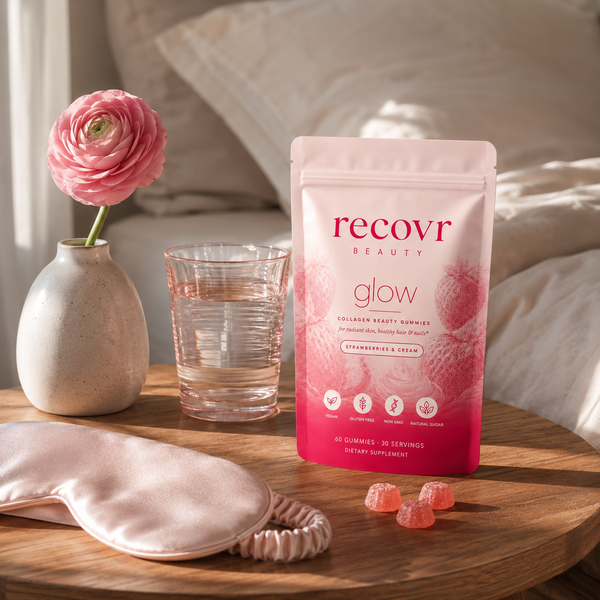 recovr glow pouch on a nightstand with a flower, water and sleep mask